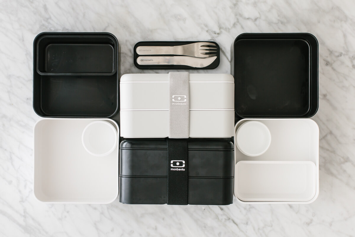 Black and white bento box containers on a countertop.