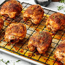 Baked chicken thighs on a sheet pan.