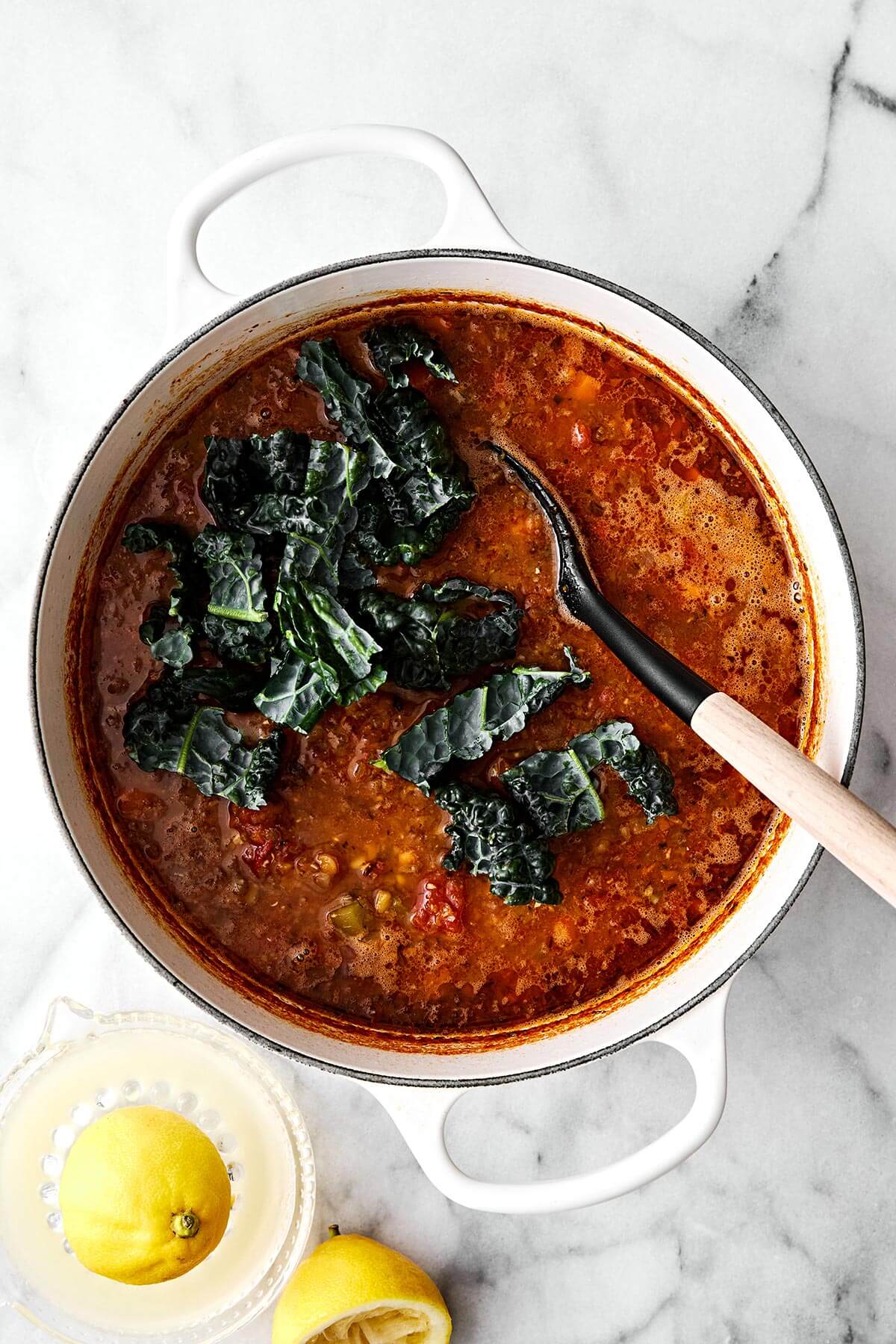 Lentil soup is the perfect vegetarian meal to cozy up with for fall and winter. It’s hearty, healthy, and wonderfully filling thanks to its plant-based protein. And while there are many variations of lentil soup, this simple and vibrant Mediterranean version is extra special. Stirring in kale into lentil soup.
