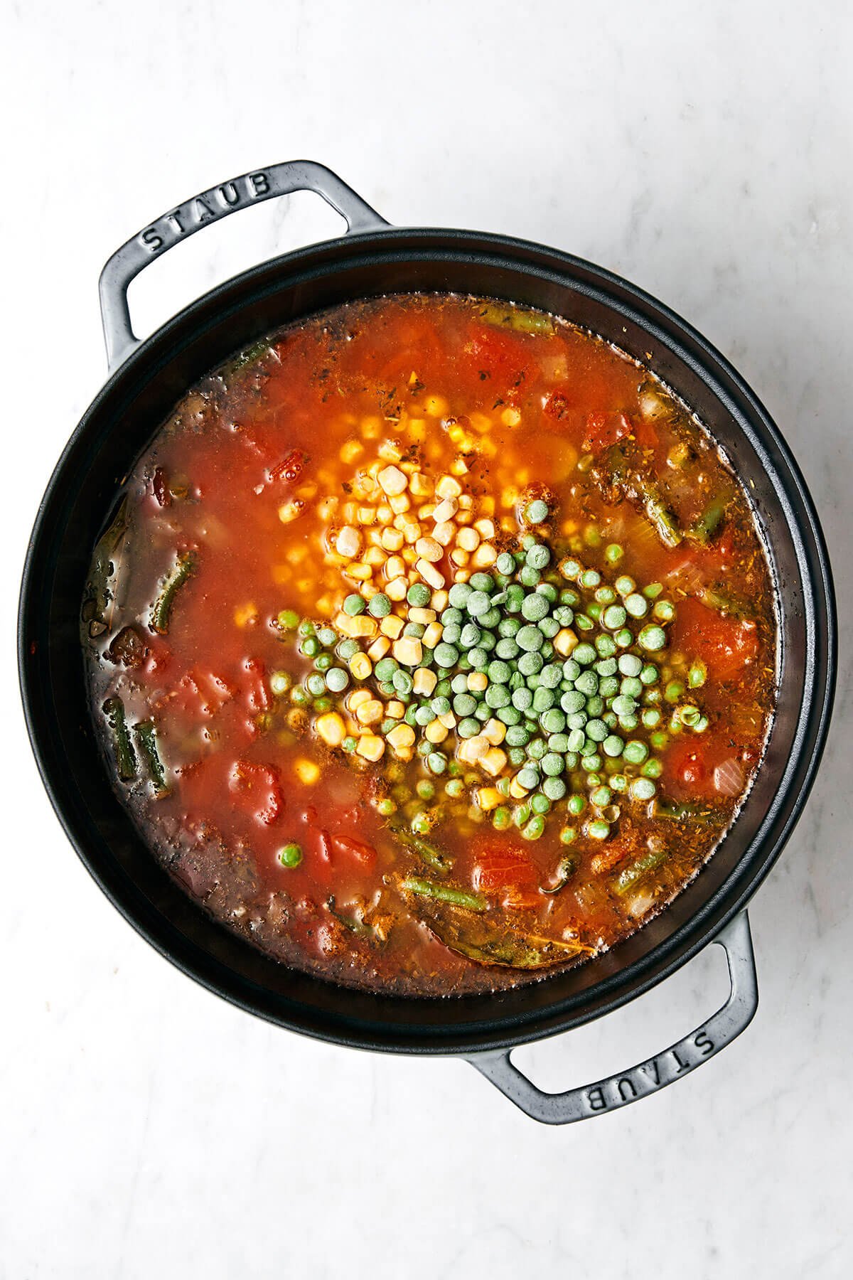This easy vegetable soup recipe is packed with flavor and healthy vegetables, and is perfect for fall and winter soup season! Cooking vegetable soup in a pot