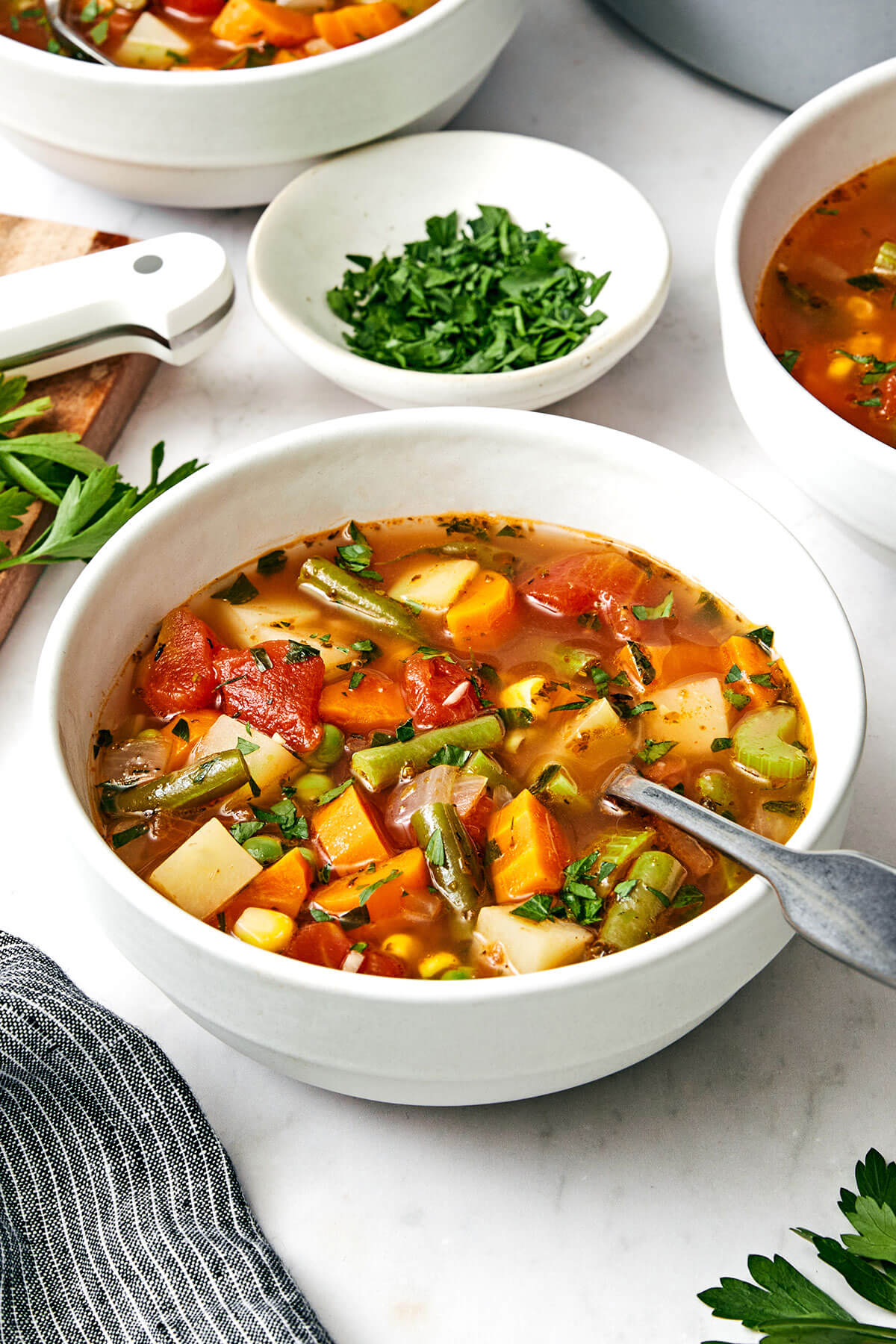 This easy vegetable soup recipe is packed with flavor and healthy vegetables, and is perfect for fall and winter soup season! A bowl of vegetable soup with a spoon