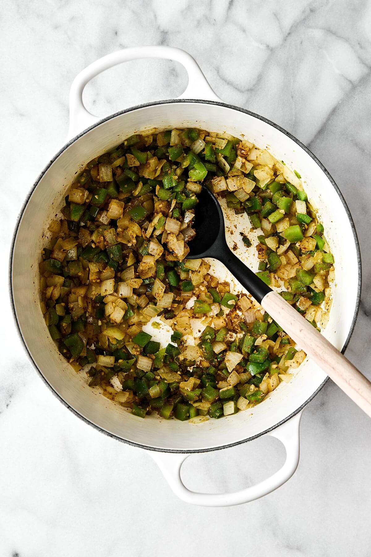This white chicken chili is a fall/winter comfort food favorite and a flavorful blend of tender chicken, white beans, sweet corn, green chiles, and more! Cooking vegetables in a pot.